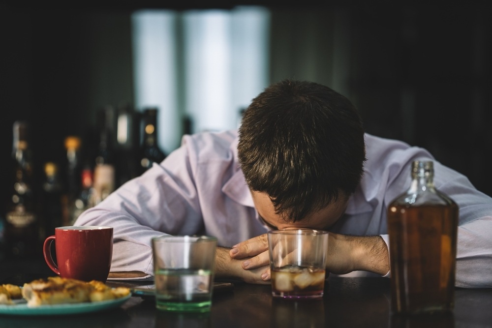 Person asleep at a bar table surrounded by empty drink glasses, representing a Newark dram shop liability case