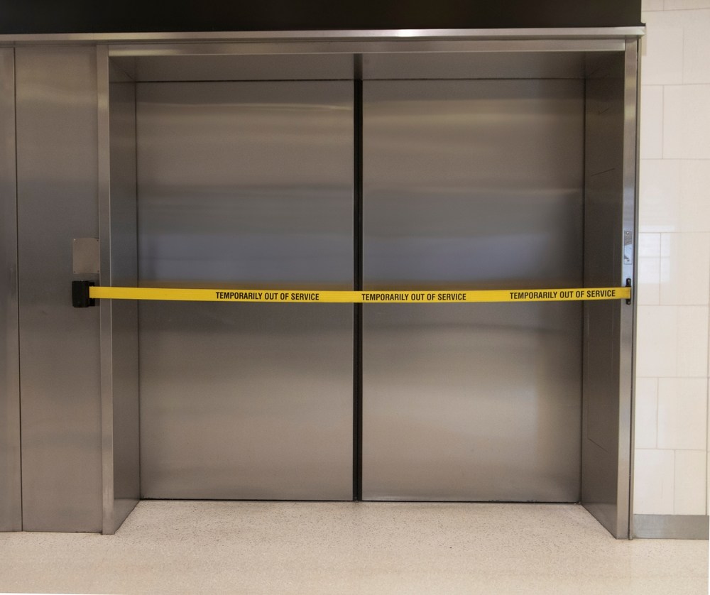 Elevator doors taped off with an out of service sign following a malfunction and injury