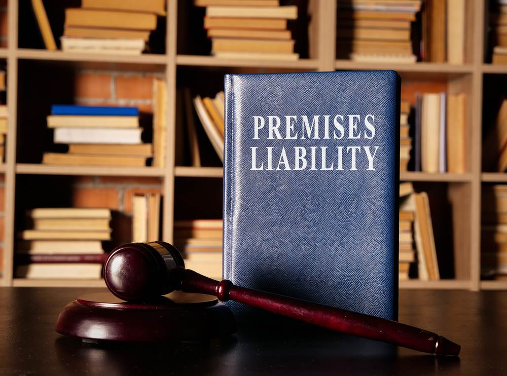Premises liability law book standing beside a judge's gavel on a desk, representing New Jersey property owner injury claims