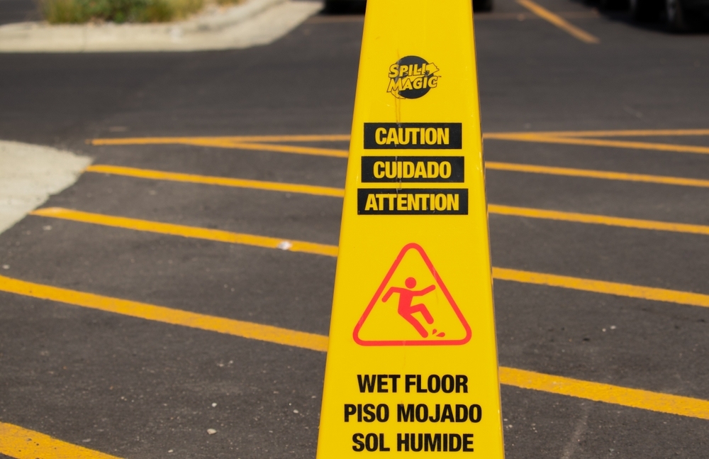 Yellow caution cone warning of a wet or slippery surface in a parking lot, relevant to notice and hazard warnings in premises liability cases