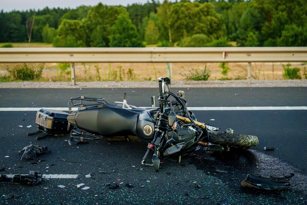 Damaged motorcycle lying on a highway with debris scattered nearby, illustrating the aftermath of a Newark motorcycle accident