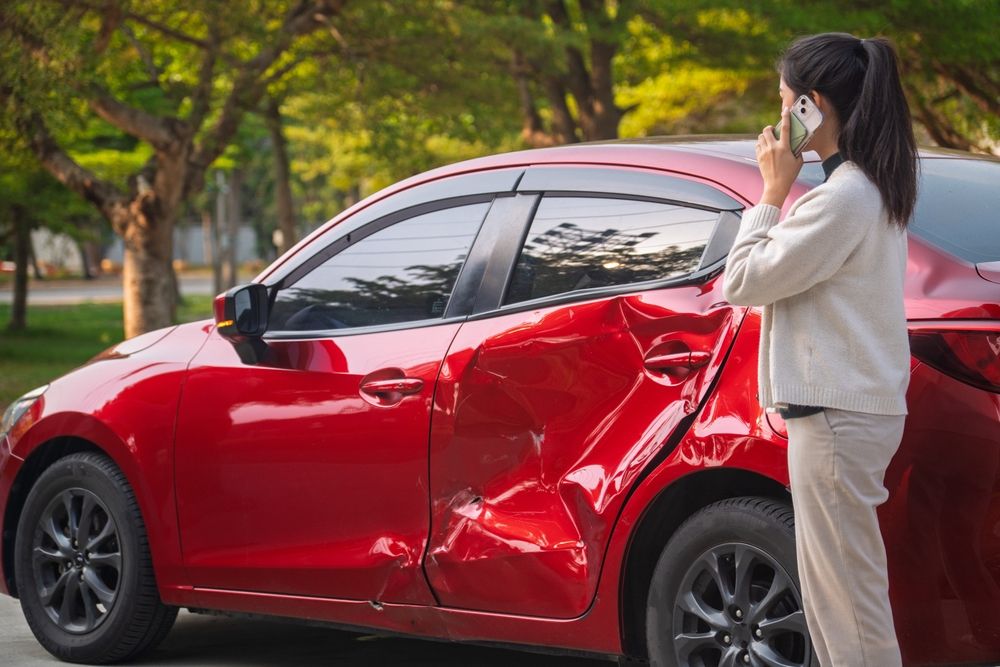 Woman calling for help after a car accident before delayed injury symptoms appear